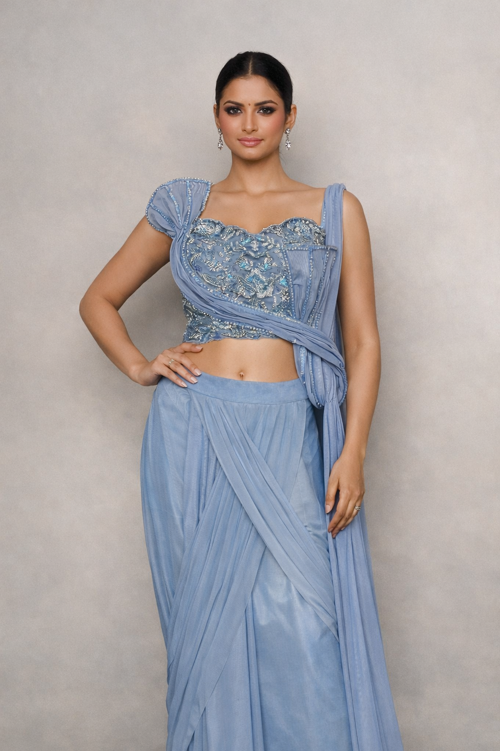 Woman wearing a light blue saree with a matching blouse of handwork