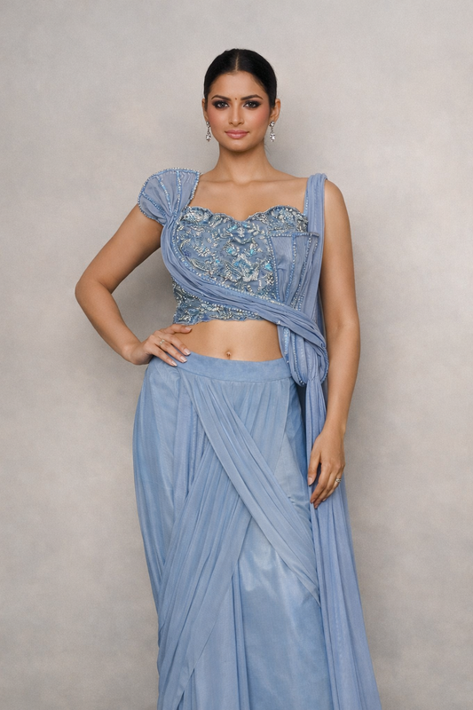 Woman wearing a light blue saree with a matching blouse of handwork